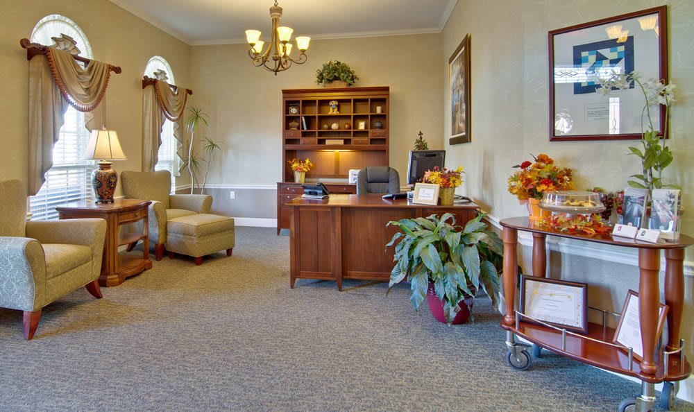 A well-decorated office space with a wooden desk, bookshelf, and plants.