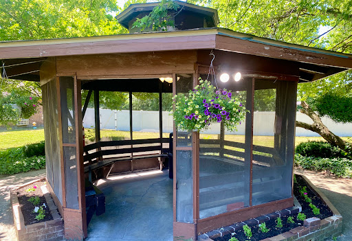 A serene wooden gazebo surrounded by lush greenery, perfect for relaxation.