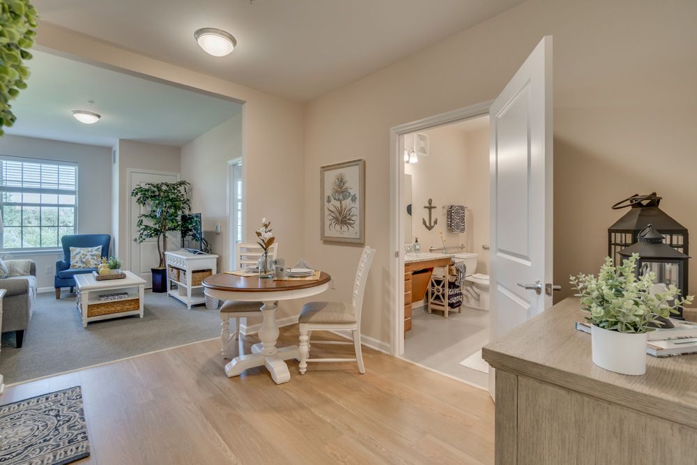 A cozy interior view featuring a small dining area, living room, and adjoining bathroom.