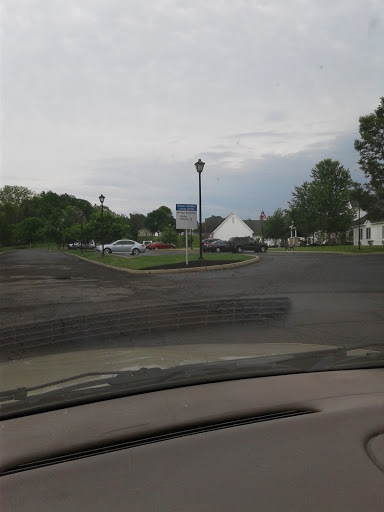 A view of an intersection with a traffic sign under a cloudy sky.