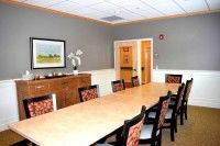 A well-lit conference room with a long table and chairs.