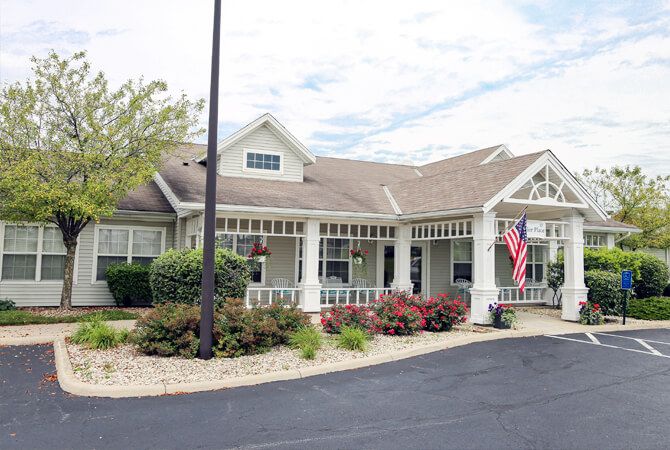 A residential building with an American flag and neatly maintained landscaping.