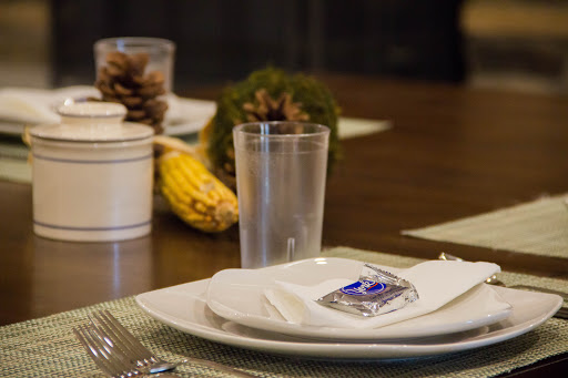 A beautifully arranged dining table featuring elegant dinnerware and seasonal decor.