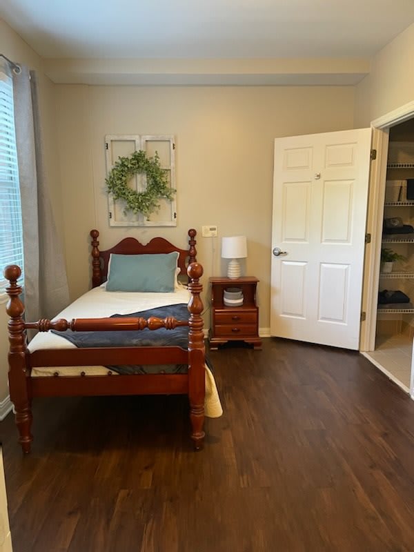 Cozy bedroom with a single wooden bed and nightstand.