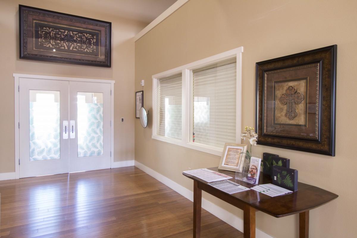 A well-decorated entryway featuring a wooden table with framed photos and artwork on the walls.