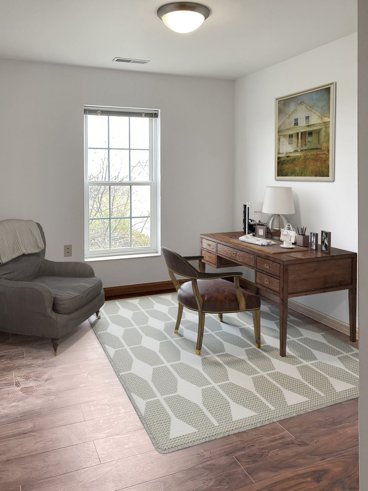 A cozy home office with a desk, chair, and armchair near a window.