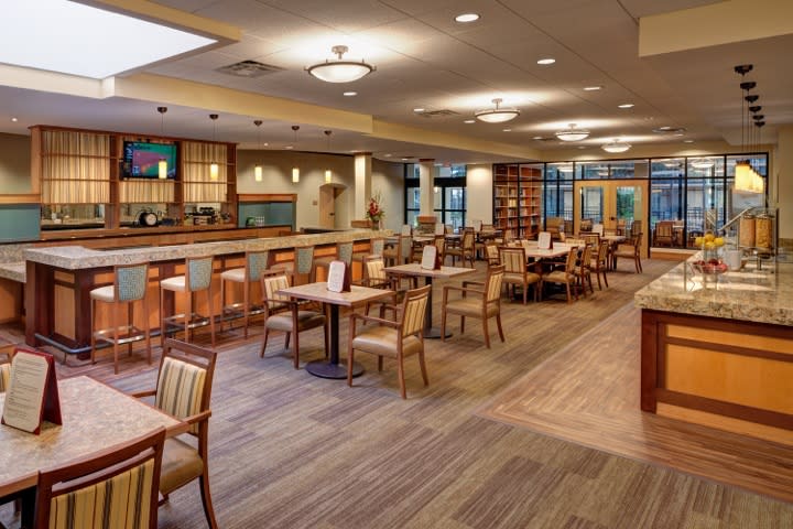 An empty restaurant dining area with neatly arranged tables and chairs.