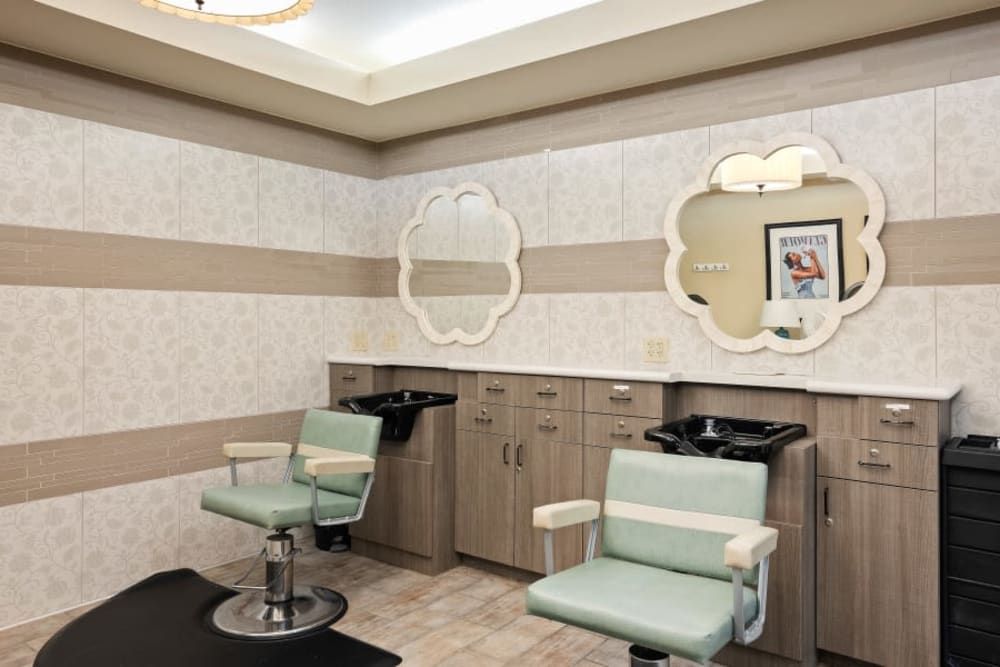 A vintage-style hair salon interior with two barber chairs and mirrors.