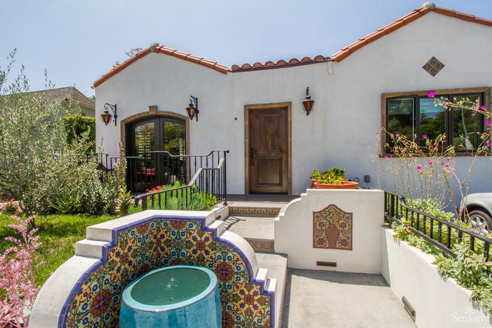 A charming Spanish-style house with a colorful tiled fountain in the courtyard.