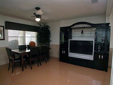 A modern living room with a dining table and a large TV entertainment unit.