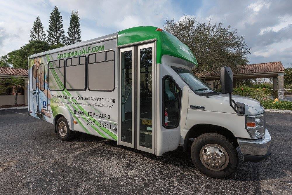A green and white shuttle bus parked on a road.