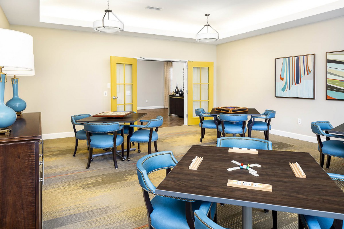 A brightly lit game room with modern tables and chairs.