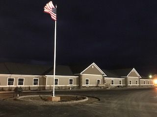 A building with an American flag flying at night, illuminated by lights.