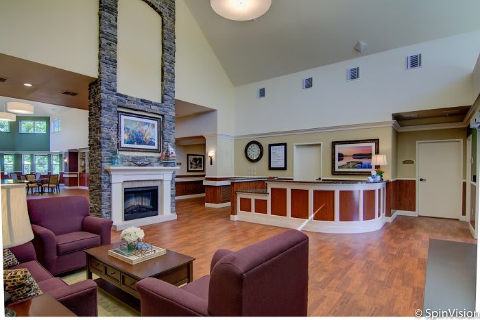 A cozy lobby with a fireplace, reception desk, and comfortable seating.