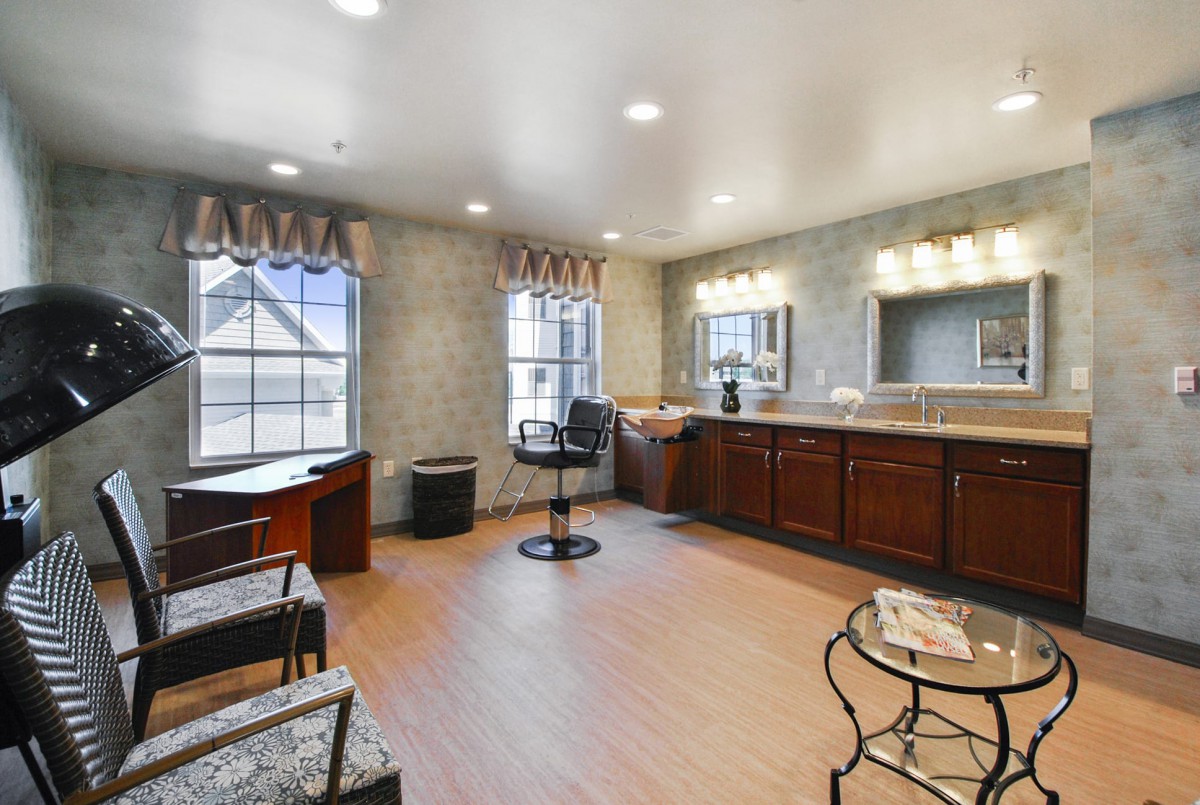 A well-lit salon interior with a barber chair, mirrors, and wooden cabinets.