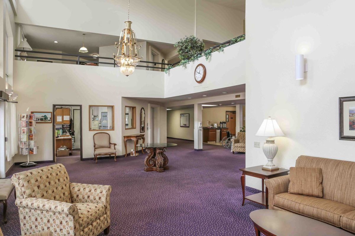 A spacious lobby area with comfortable seating and a large chandelier.