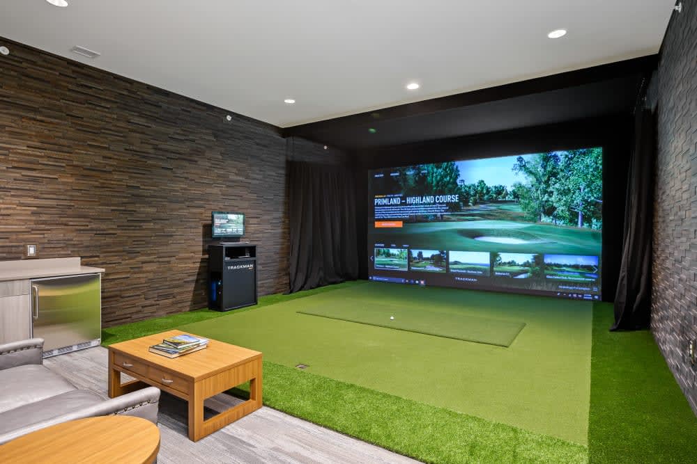 An indoor golf simulator setup in a modern entertainment room.