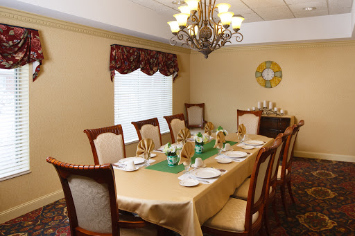 A beautifully arranged dining room featuring an elegant table setting under a decorative chandelier.