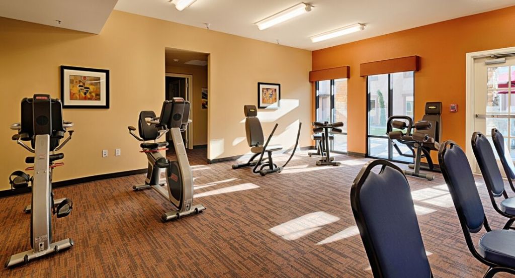 A well-lit gym with various exercise equipment.
