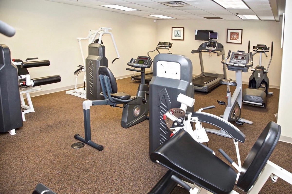 A well-equipped gym room featuring various exercise machines and treadmills.