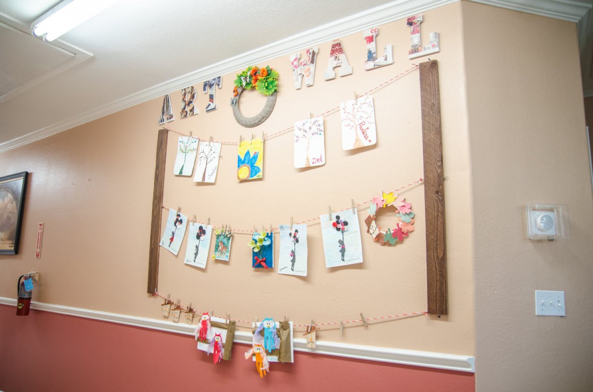 A creative wall display featuring children's artwork and crafts.
