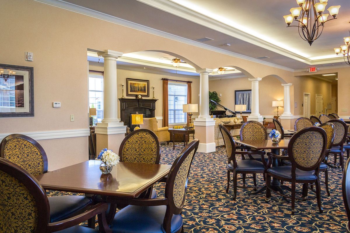 A neatly arranged dining area with elegant furniture and warm lighting.