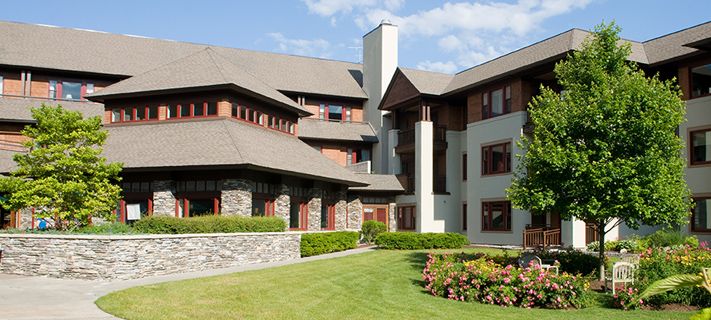 A modern residential building with a well-maintained lawn and garden.