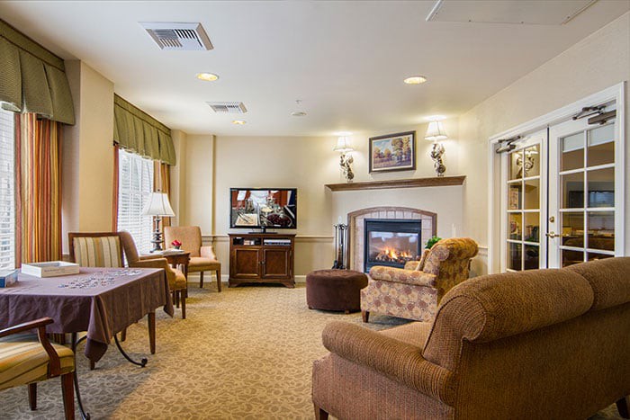 A cozy living room featuring a fireplace, comfortable seating, and warm decor.