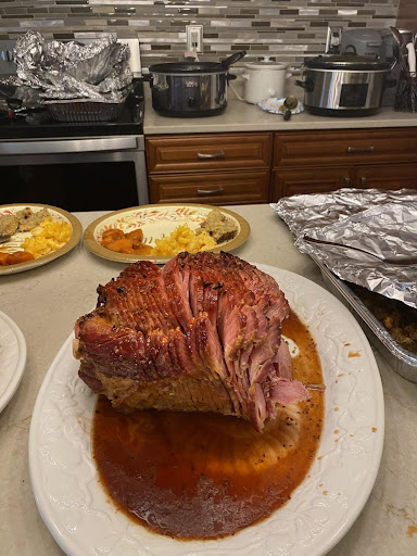 A beautifully glazed ham served on a platter, surrounded by side dishes.