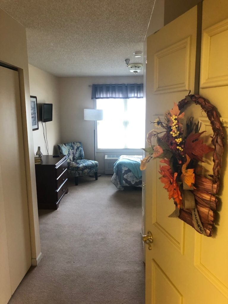 A cozy bedroom view from the door with autumn-themed decor.