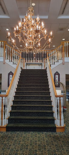 A grand staircase featuring a beautiful chandelier, inviting guests into an elegant space.