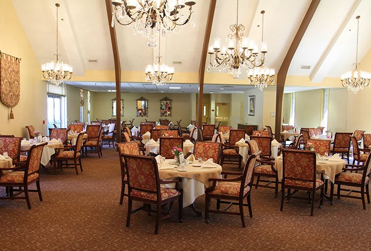 An elegant dining room with arranged tables and chandeliers.