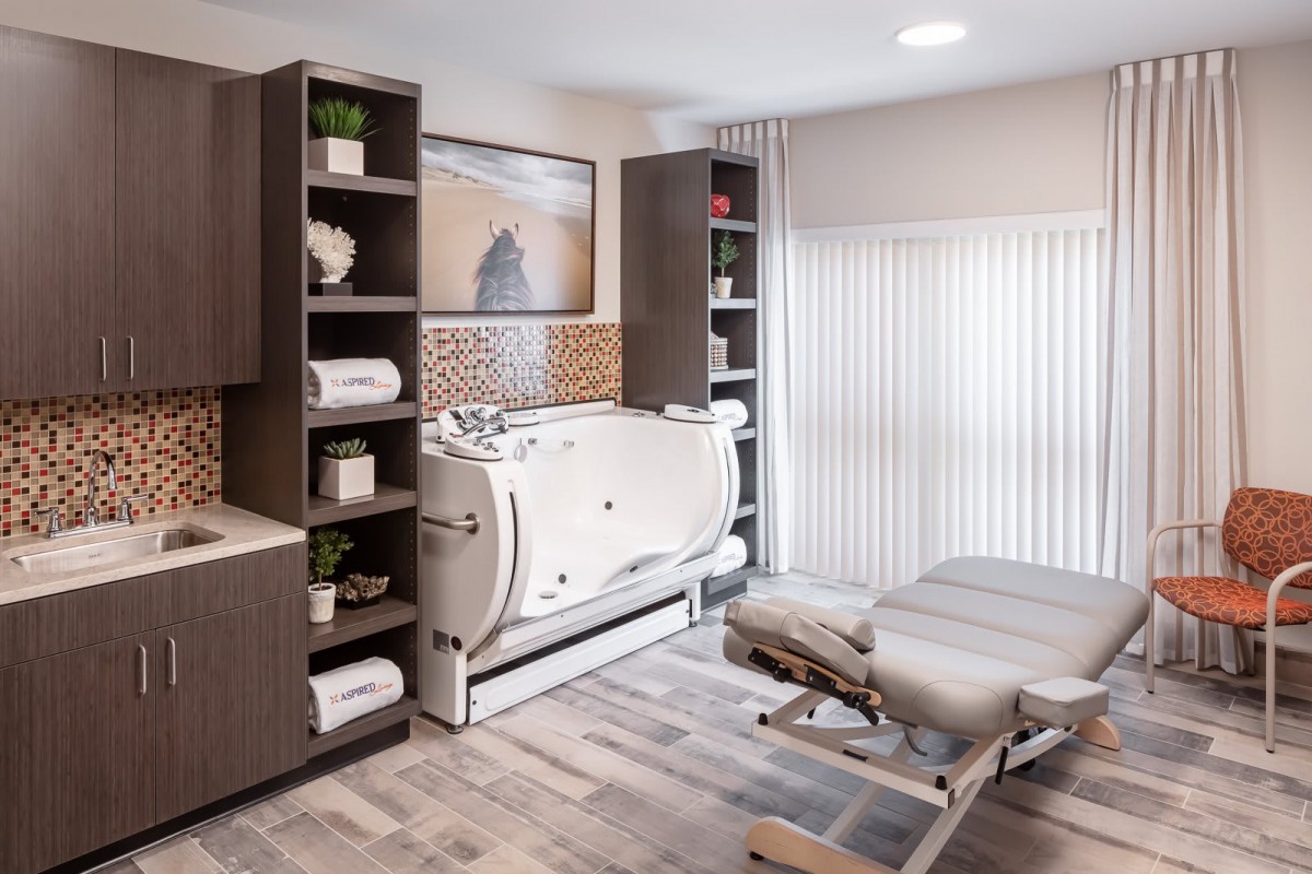 A modern spa bathroom featuring a luxury bathtub and well-organized shelving with towels.