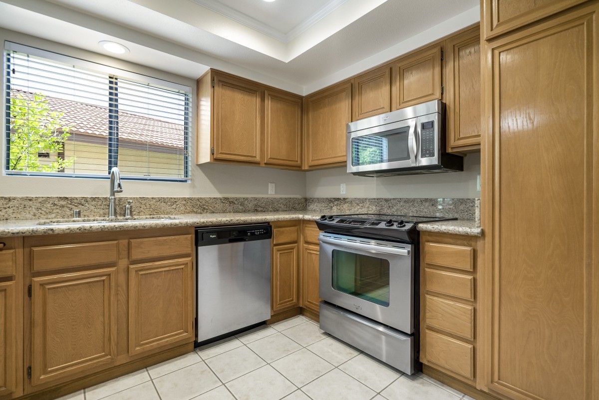 A modern kitchen with wooden cabinets and stainless steel appliances.