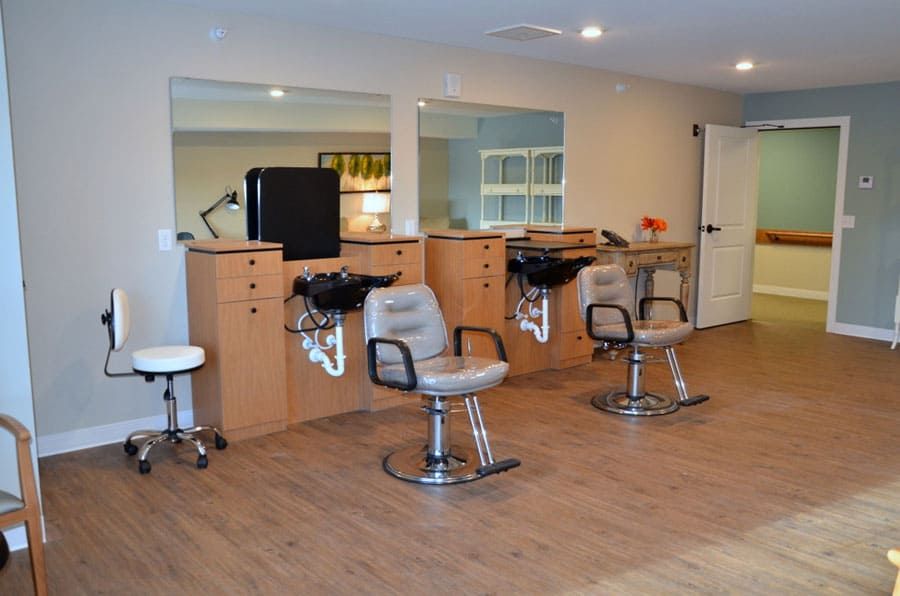 A spacious and modern hair salon with styling chairs and mirrors.