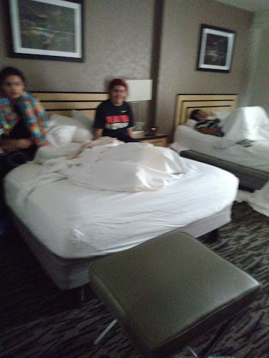 A relaxed moment in a hotel room with friends lounging on the beds.