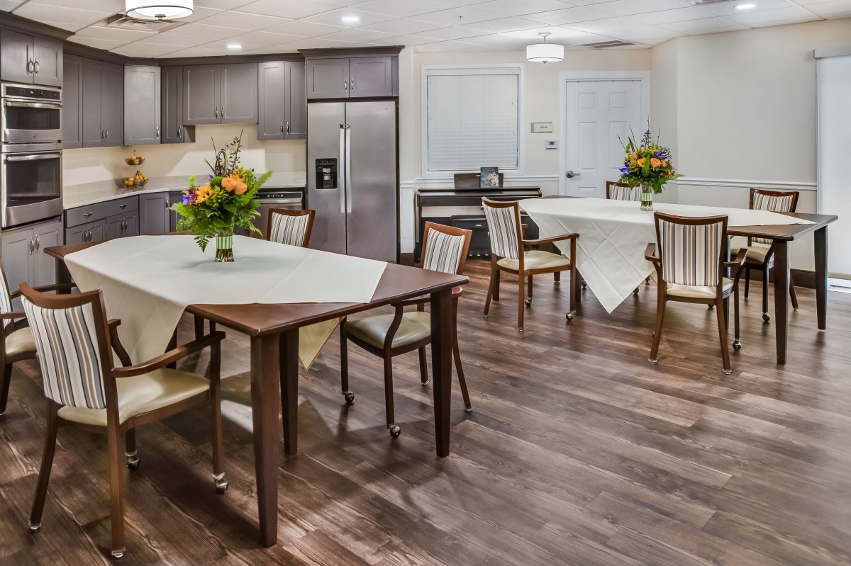 A modern kitchen and dining area with elegant furnishings and floral decorations.