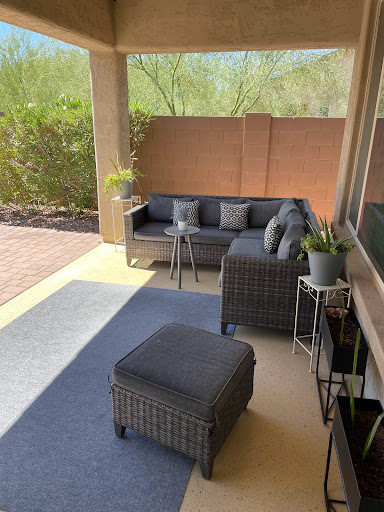 A cozy outdoor patio setup featuring modern furniture and potted plants.