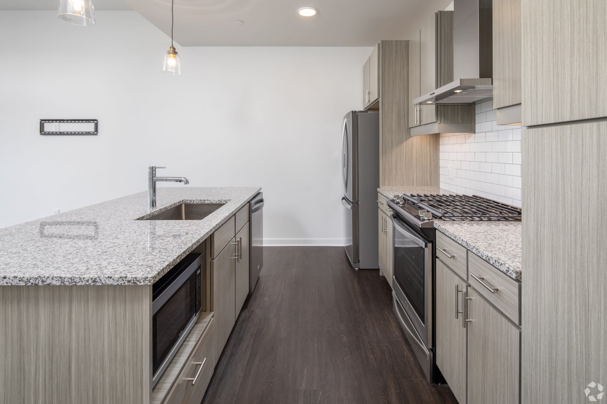 Modern kitchen with sleek appliances and granite countertops.