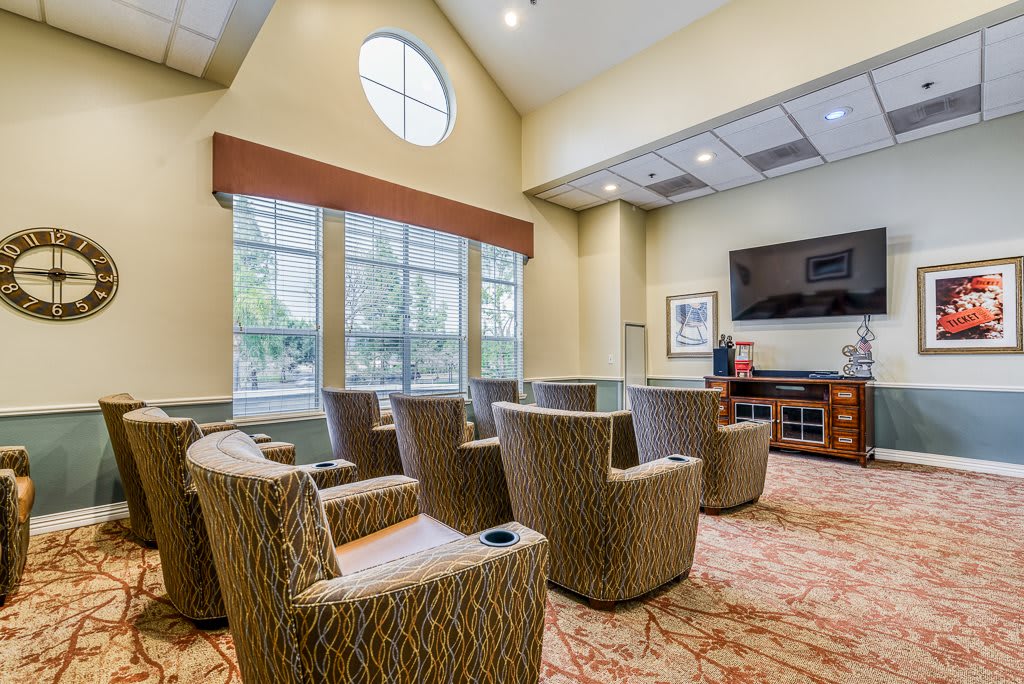 A comfortable waiting room with chairs arranged around a television.