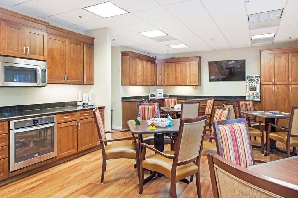 A cozy kitchen and dining area with wooden cabinets and striped upholstered chairs.