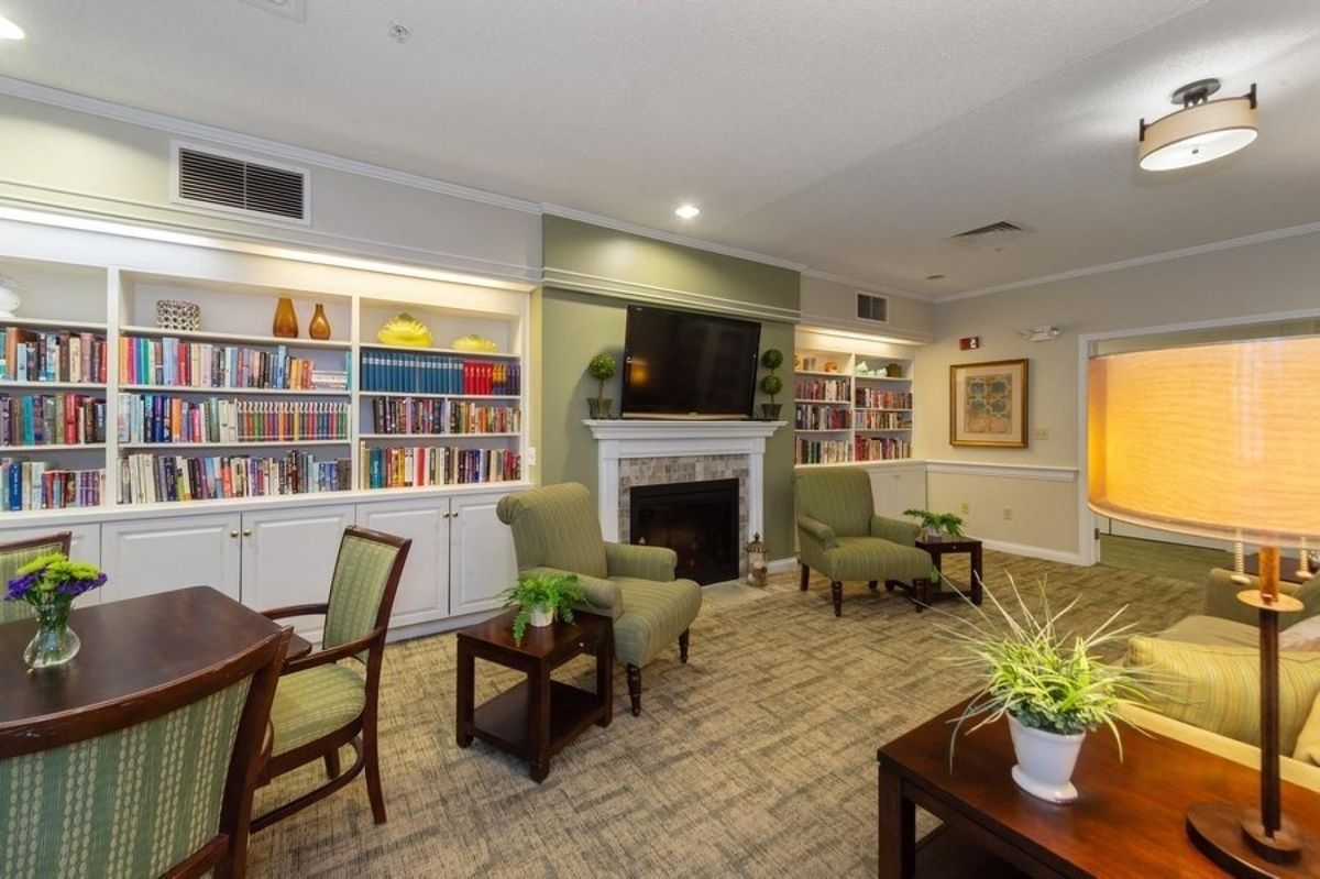 A cozy living room with bookshelves, a fireplace, and comfortable seating.
