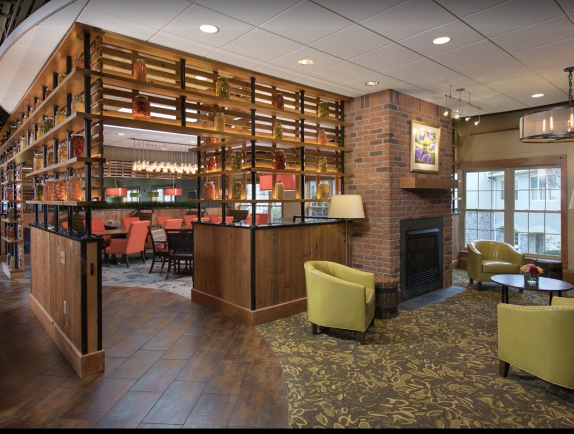 A cozy lounge area with modern design elements, featuring a fireplace and bar seating.