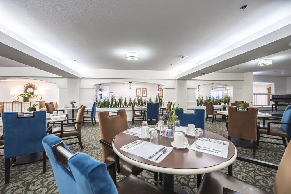 A spacious dining area with neatly arranged tables and chairs, set for a meal.