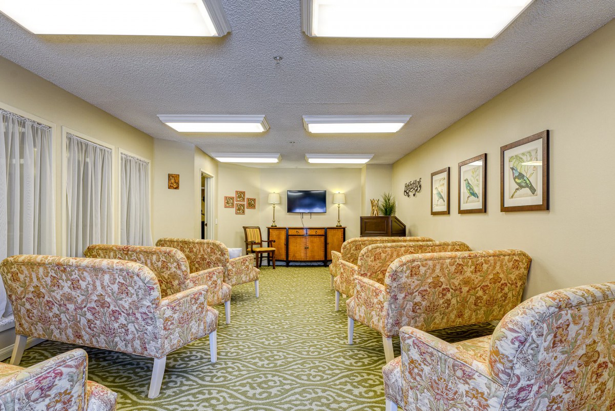 A spacious and well-lit waiting room with patterned chairs and artwork on the walls.