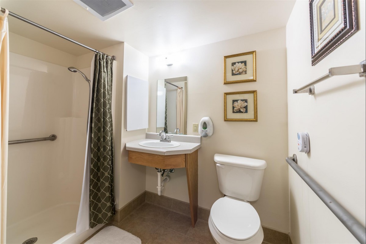 A clean and simple bathroom setup with a shower, sink, and toilet.