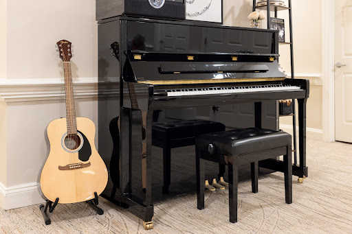 A stylish black piano accompanied by an acoustic guitar, perfect for a music-filled space.