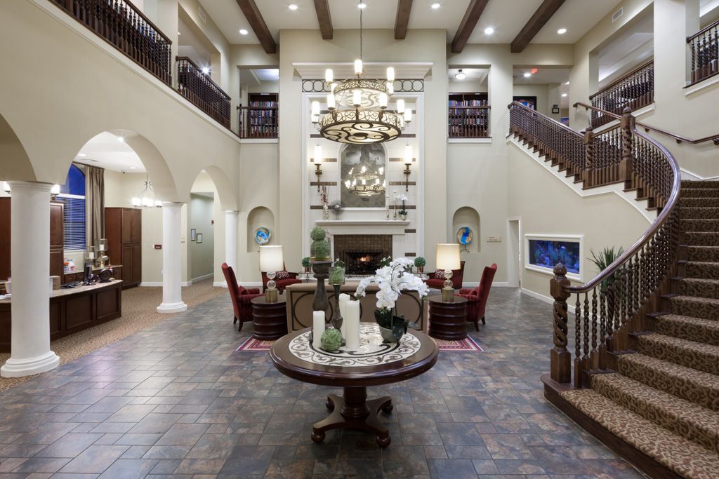 Spacious luxury living room with high ceilings, elegant furniture, and a grand chandelier.