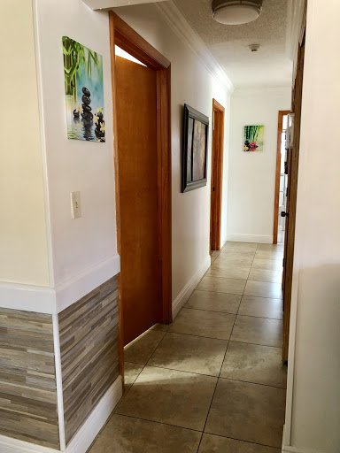 A well-lit hallway showcasing wooden doors and decorative artwork.