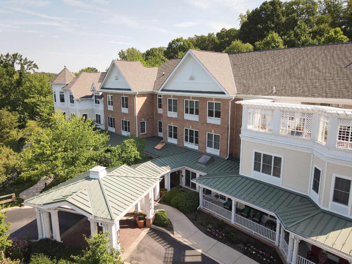Aerial view of a residential building with trees and a covered entrance.